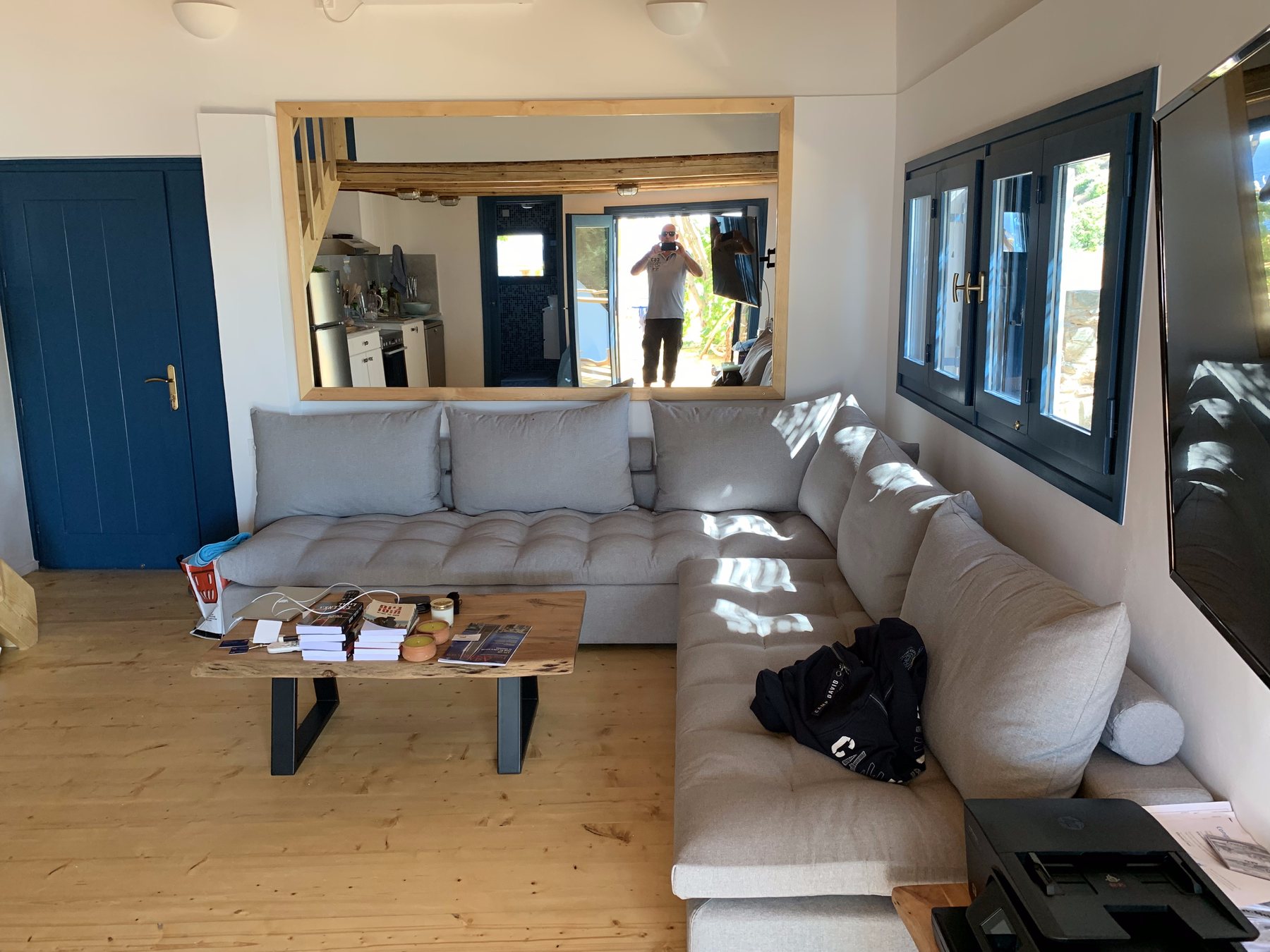 Living room with a large sectional sofa, mirror and blue door