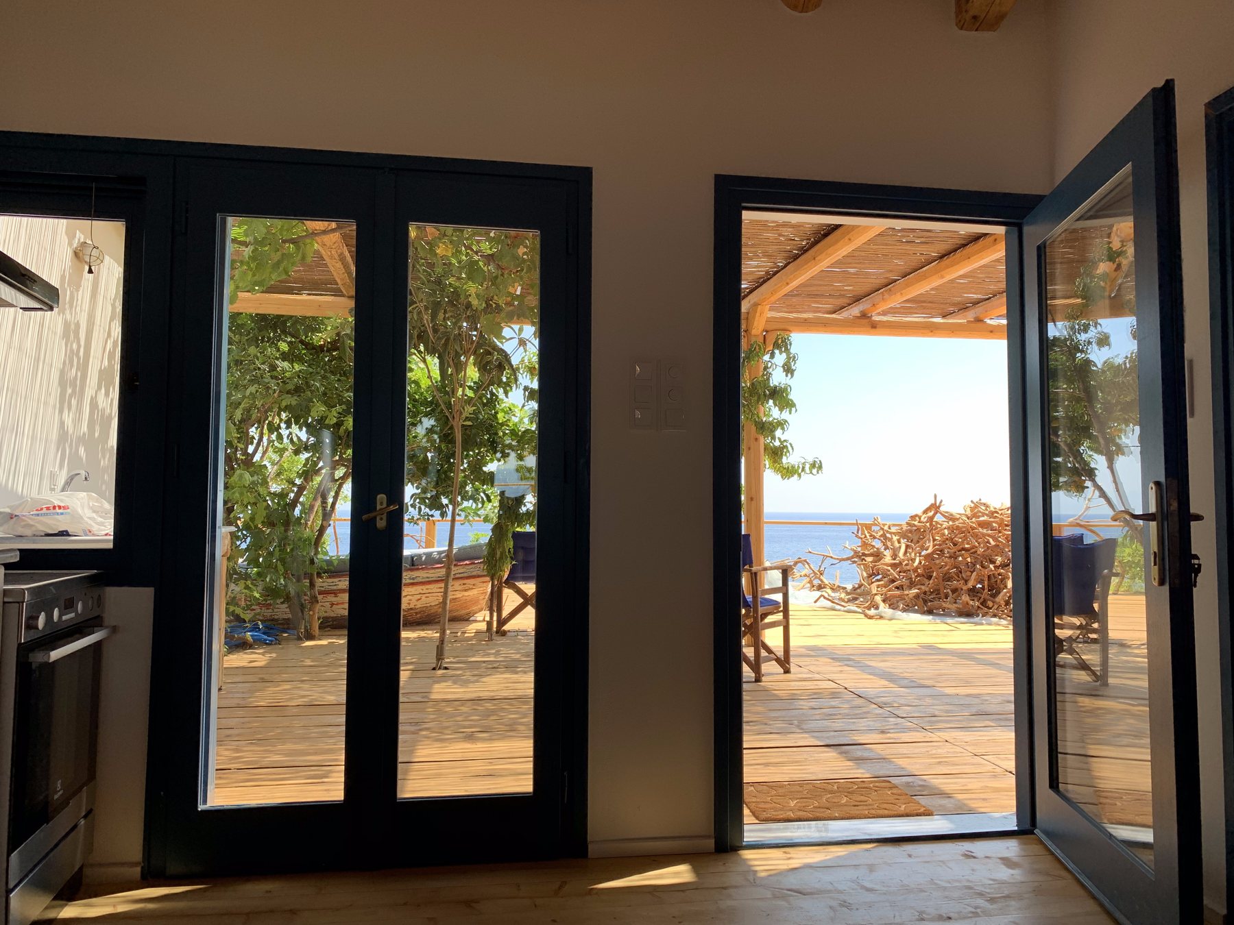 Sofa looking through blue doors onto the deck and the sea