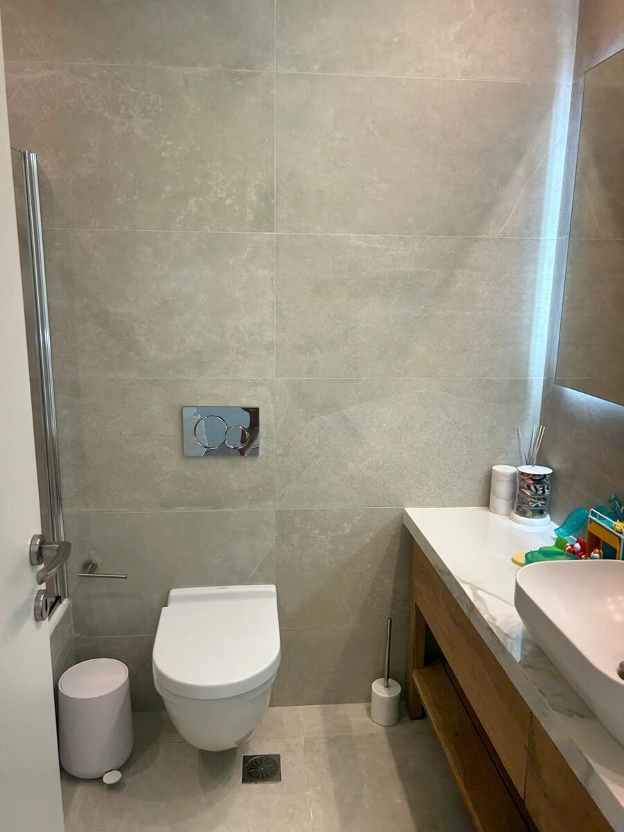 Third bathroom — stone-tile WC and vanity, currently serving the child’s room